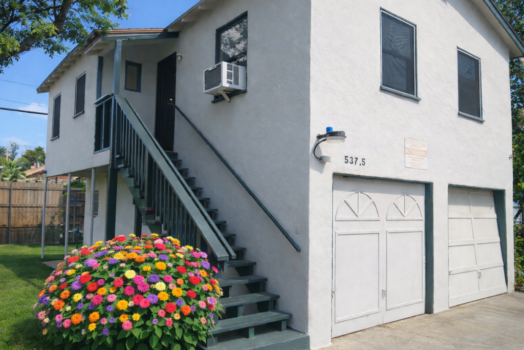 Exterior facade of the San Francisco Street location house with manicured hedges and distinct architectural lines.